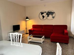 a living room with a red couch and a table at El Chalet de Lola in Playa de Miramar