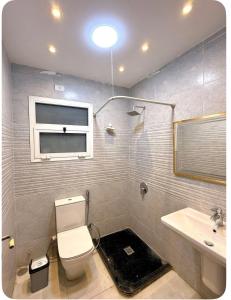 a bathroom with a toilet and a sink at شقة فندقيه بمدينتي in Madinaty