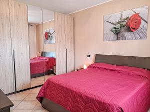 a bedroom with a red bed and a mirror at Appartamento Roverella in Rovigo
