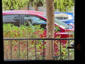 a red car parked next to a tree at SĀN Living in Golem