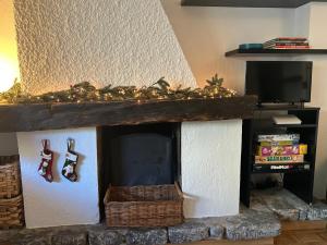 a fireplace with christmas ornaments and a tv at Tranquillità Vintage al Verrand con 3 camere in Verrand