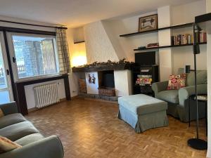 a living room with a couch and a fireplace at Tranquillità Vintage al Verrand con 3 camere in Verrand