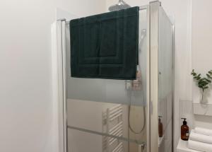 a bathroom with a shower with a green towel at La casa Rio de Janeiro - parking & confort in Trignac