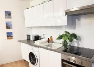 a white kitchen with a sink and a dishwasher at La casa Rio de Janeiro - parking & confort in Trignac