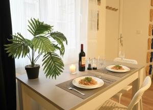 a table with two plates of food and a bottle of wine at La casa Rio de Janeiro - parking & confort in Trignac +14 photos