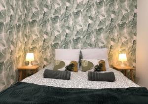 a bedroom with a bed with two lamps on two tables at La casa Rio de Janeiro - parking & confort in Trignac