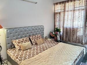 a bedroom with a bed with pillows on it at Happy Homes 2BHK Second Floor Panchkula in Panchkula