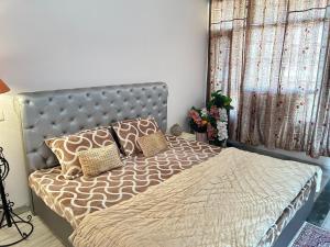 a bedroom with a bed with a headboard and pillows at Happy Homes 2BHK Second Floor Panchkula in Panchkula +11 photos