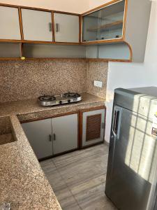 a kitchen with a stainless steel refrigerator and cabinets at Happy Homes 2BHK Second Floor Panchkula in Panchkula
