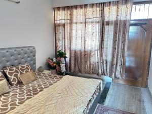 a bedroom with a bed and a window with curtains at Happy Homes 2BHK Second Floor Panchkula in Panchkula