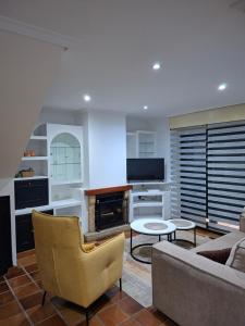 a living room with a couch and a tv at Casa Robleda, Piscina privada cubierta y Jacuzzi in Vigo