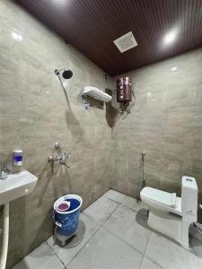 a bathroom with a toilet and a sink at Hotel Sambhavi in Hisua