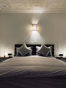 a bedroom with a large bed with a light above it at Inass appartement in Essaouira