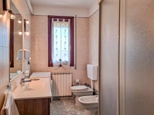 a bathroom with a toilet and a sink and a window at Appartamento Roverella in Rovigo +37 photos