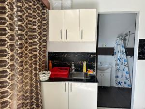 a kitchen with white cabinets and a sink at Cozy Self-contained Unit in Lautoka