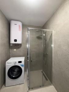 a shower stall with a washing machine in a bathroom at Bozovic Apartman 2 in Budva
