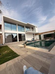 a person laying in front of a house with a swimming pool at La villa Bella Vista in Somone