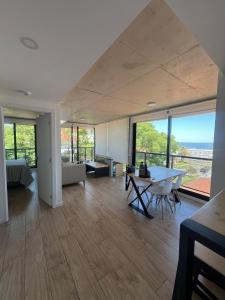 a large living room with a table and some windows at Apartamento Piriapolis in Piriápolis
