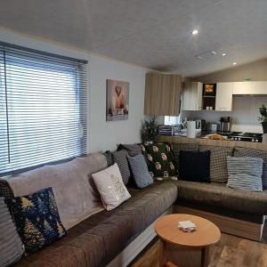a living room with a couch and a table at Centrix at Seawick Holiday Park in Saint Osyth