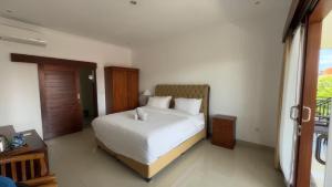 a bedroom with a white bed in a room at LA Homestay sanur in Sanur