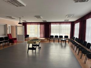 a conference room with chairs and tables and a podium at Arkánum Wellness Hotel in Balatonmáriafürdő