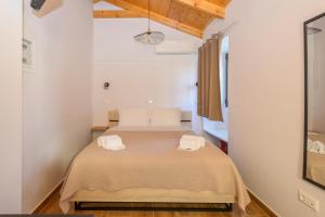 a bedroom with a bed with two towels on it at Voidοkilia rooms in Petrochori