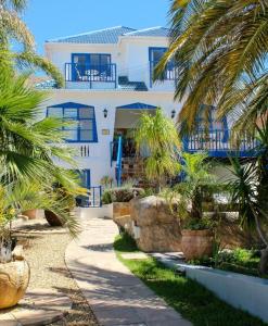 a white house with palm trees in front of it at Portview and Brenwin Guesthouse in Cape Town