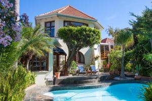 a house with a swimming pool in front of a house at Portview and Brenwin Guesthouse in Cape Town