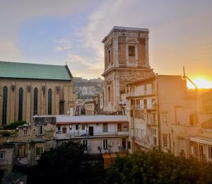 an old building with a clock tower in a city at Le Ninfe Luxury Rooms in Naples
