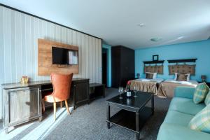 a hotel room with a bed and a desk and a couch at Wellness Hotel Bulgaria in Bansko