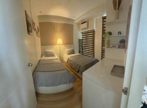 a small room with two beds and a counter at Miyu's Staycation Place in Biñan
