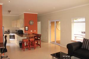 a kitchen and living room with a table and chairs at Sandy Greens Villa in Swakopmund