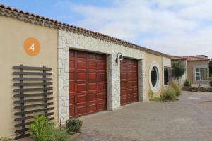a pair of red garage doors on a building at Sandy Greens Villa in Swakopmund