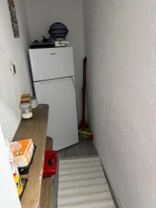 a kitchen with a white refrigerator in a room at Casa Serrana in Penhas da Saúde