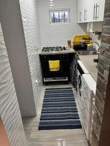 a kitchen with a stove and a rug at Casa Serrana in Penhas da Saúde