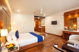 a hotel room with a bed and a desk at Hotel Gentleman Plaza in Alleppey