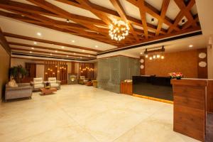 a lobby with a reception desk and chairs and a lobby at Hotel Gentleman Plaza in Alleppey