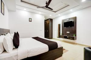 a bedroom with a bed and a flat screen tv at Yashobhoomi Grand in Jāmb +28 photos