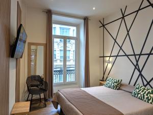 a bedroom with a large bed and a window at H33 Hôtel in Nice