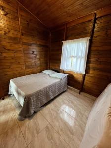 a bedroom with a bed in a wooden cabin at Refúgio Bosques de Itu in Itu +24 photos