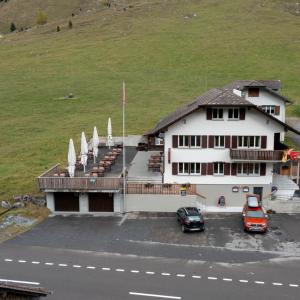 a building with a car parked in a parking lot at Gasthaus Sonne in Urnerboden