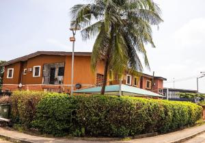 a house with a palm tree in front of it at 4 Kays Apartment in Agege