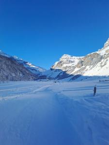a snow covered field with mountains in the background at Gasthaus Sonne in Urnerboden