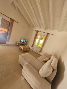 a living room with a couch and a tv at Maison de vacances in Deshaies