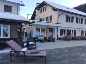 a building with chairs and tables in a courtyard at Gasthaus Sonne in Urnerboden