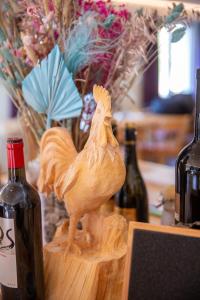 a wooden chicken sitting on a table with bottles of wine at Gasthaus Sonne in Urnerboden