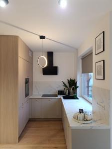 a kitchen with white cabinets and a white counter top at Apartament Kaszmir 3 in Sławno