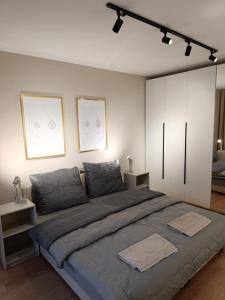 a bedroom with a large bed with two towels on it at Apartament Kaszmir 3 in Sławno