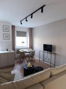 a living room with a couch and a table at Apartament Kaszmir 3 in Sławno