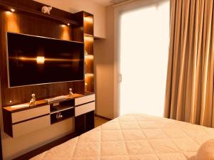 a bedroom with a flat screen tv and a bed at Departamento de lujo inteligente in Cochabamba